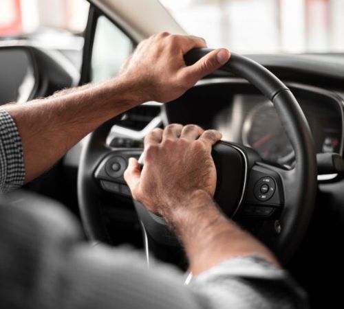 Driver holding a steering wheel