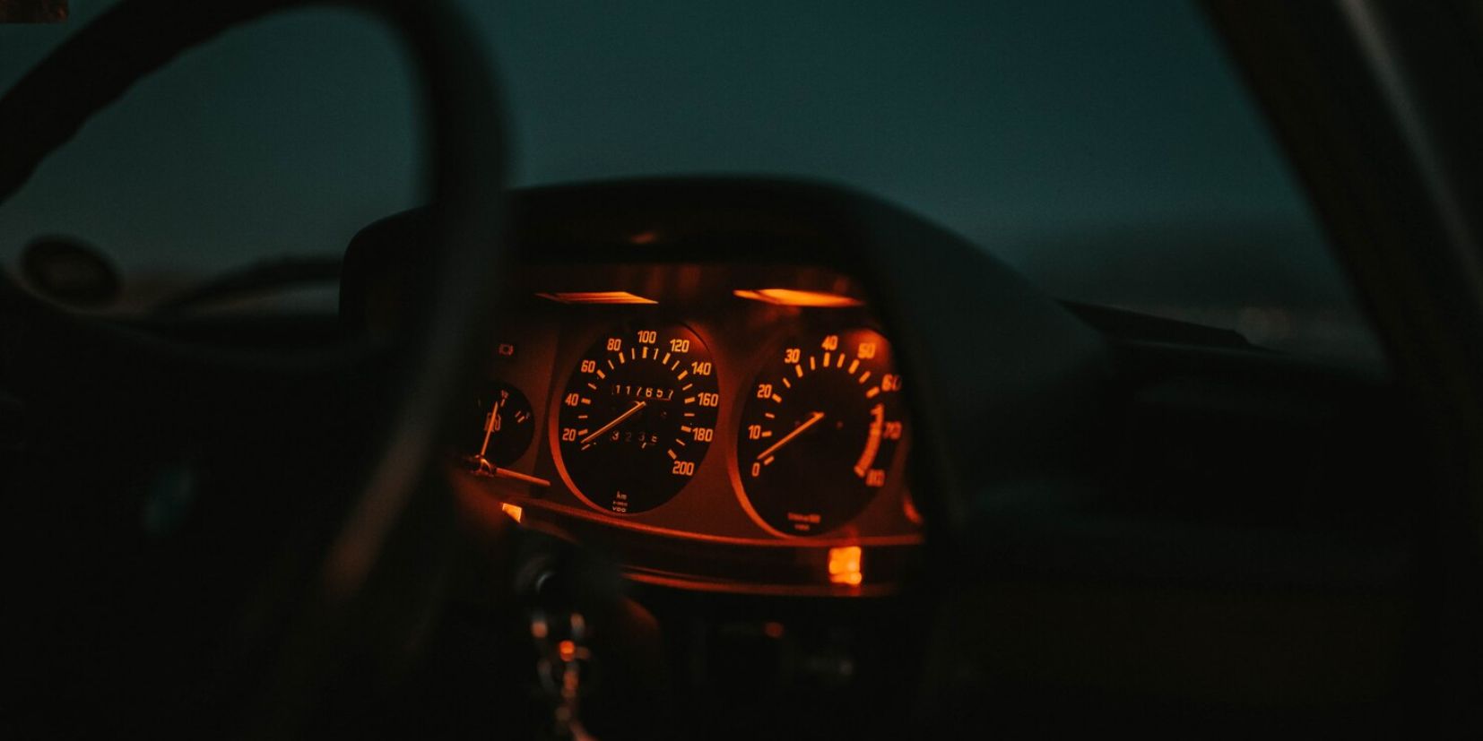 Car dashboard lit up at night