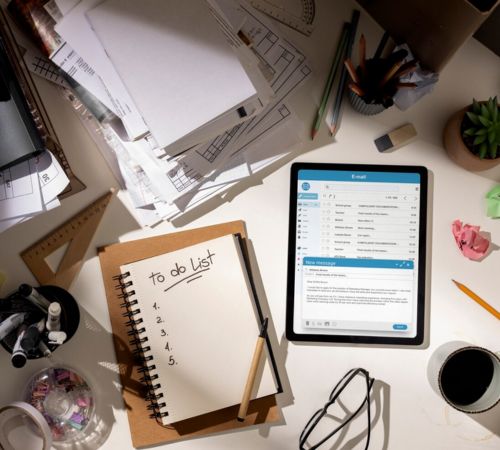 Notebook, tablet and paperwork on a desk